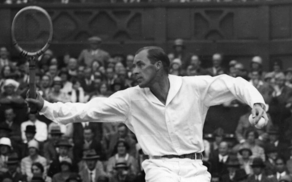 Bill Tilden playing tennis in historic match showcasing early tennis leagues intensity and grace Wallpaper