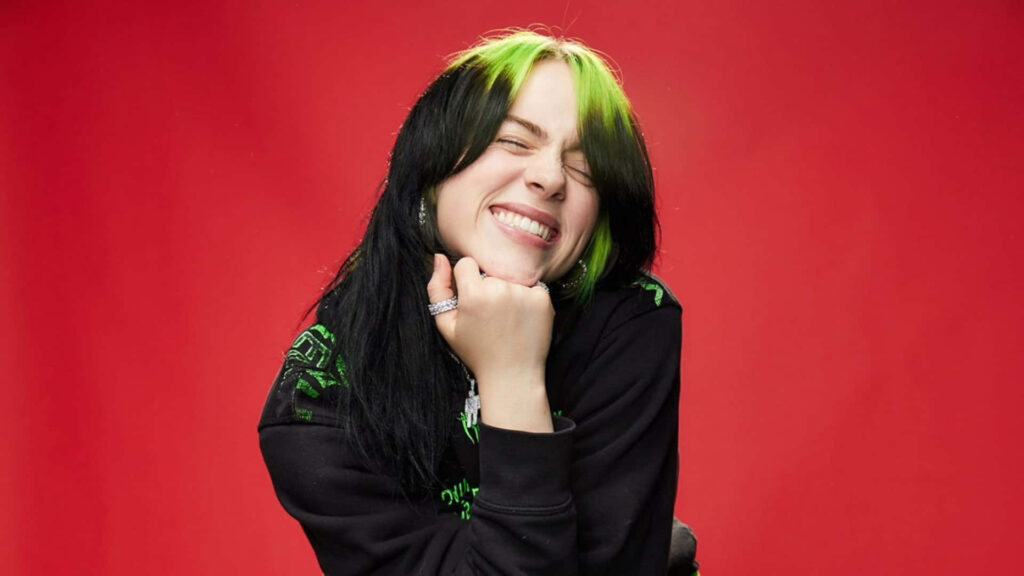 Billie Eilish Smiling Brightly - Vibrant Red Wallpaper Background