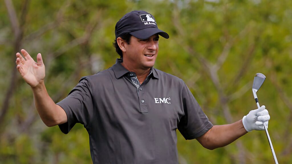 Billy Andrade on golf course wearing dark shirt and cap with lush green background and relaxed expression Wallpaper
