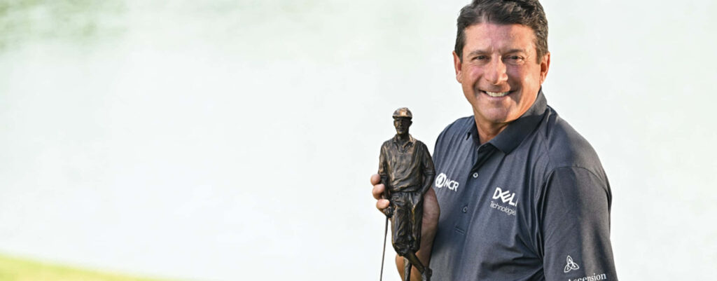 Billy Andrade smiling proudly holding golf trophy with bright serene background golf wallpaper
