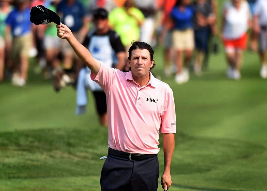 Professional Golfer Billy Andrade tips cap on vibrant golf course showing sportsmanship and pride Wallpaper