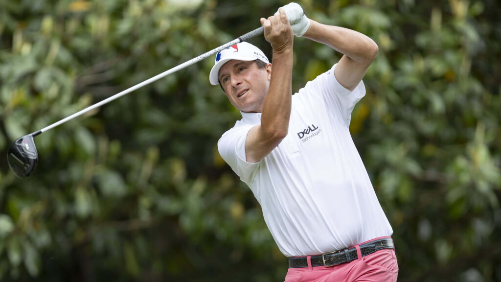 Billy Andrade mid-swing powerful golf tee shot on lush green golf course background wallpaper