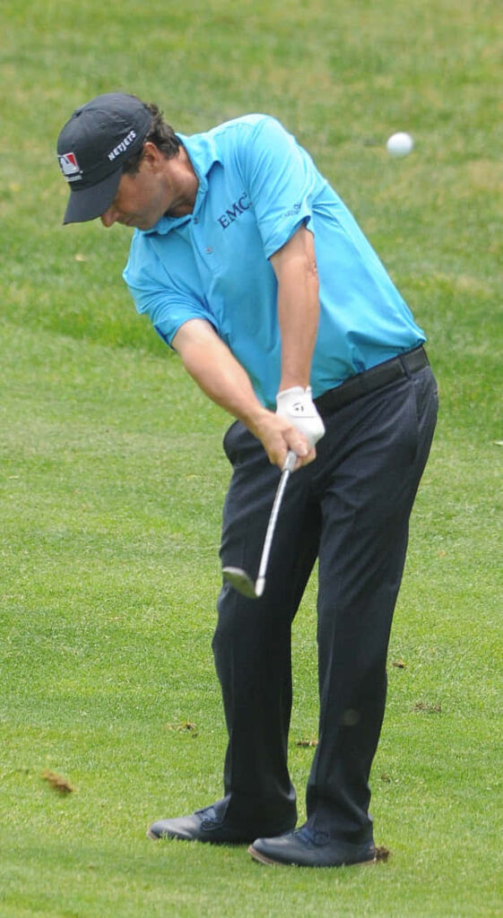 Billy Andrade professional golf swing mid-action on lush green course inspiring wallpaper background
