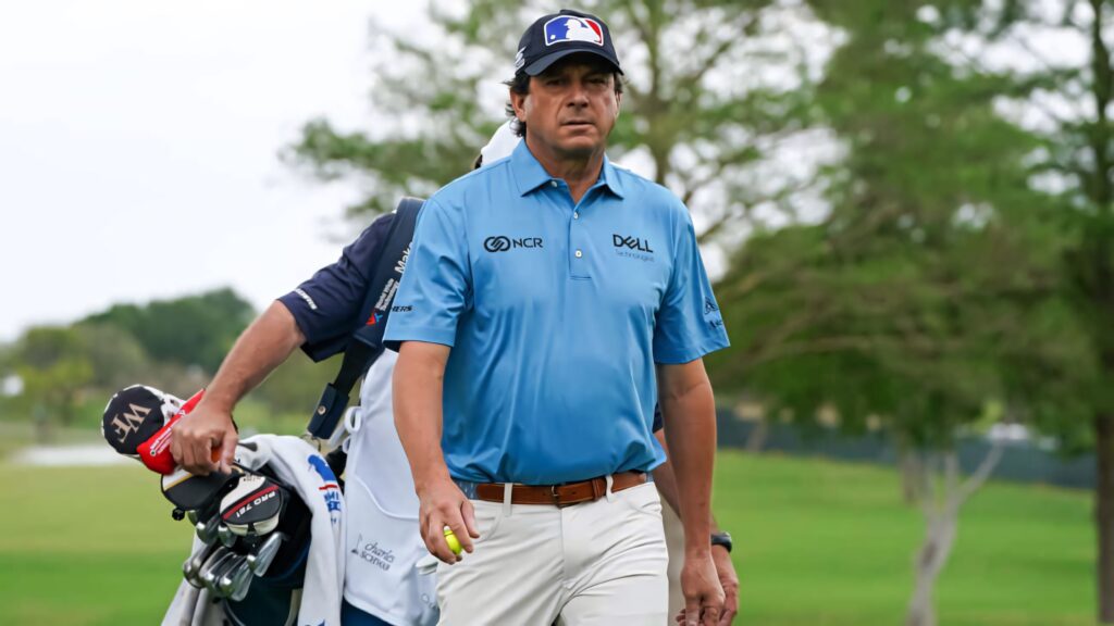 Professional golfer Billy Andrade walks with caddy on scenic golf course ready for impressive shot Wallpaper