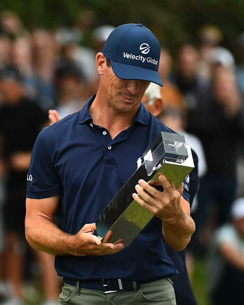 Billy Horschel proudly holds his golf trophy celebrating victory on the golf course wallpaper background