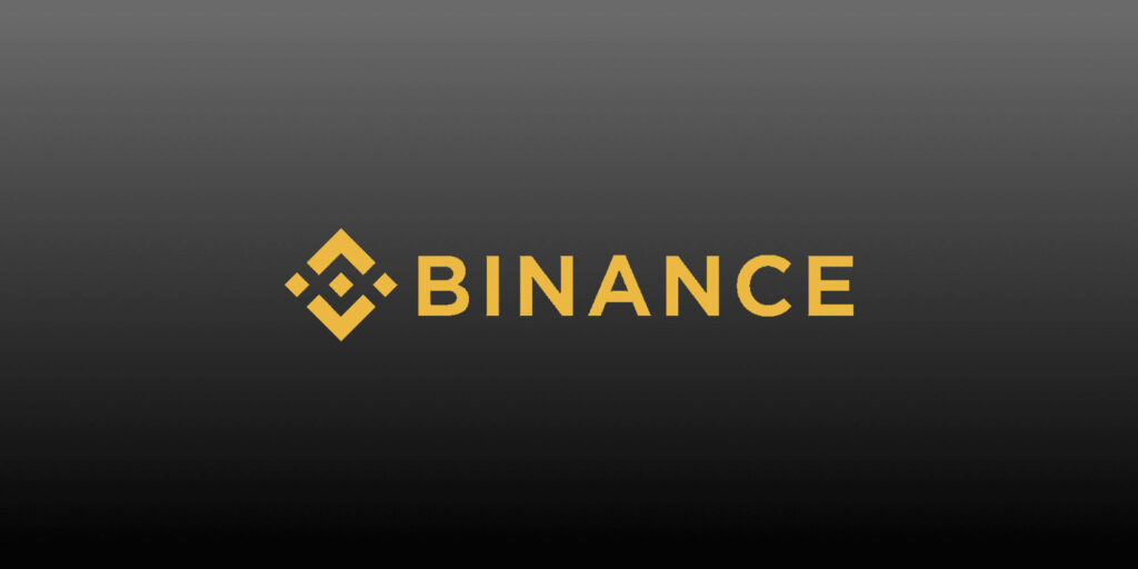 Binance logo in bold yellow on modern grey gradient background cryptocurrency wallpaper