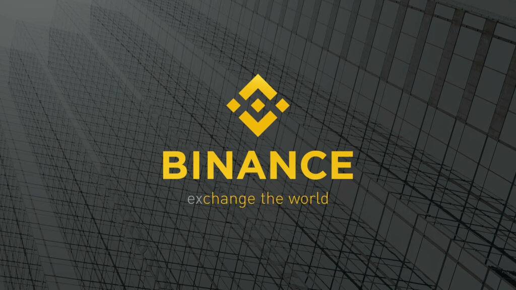 Binance yellow logo with exchange the world tagline on modern cityscape wallpaper background