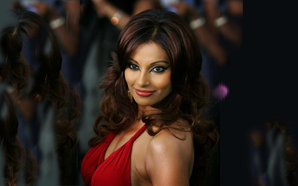 Bipasha Basu in a glamorous red dress posing confidently with blurred elegant background wallpaper
