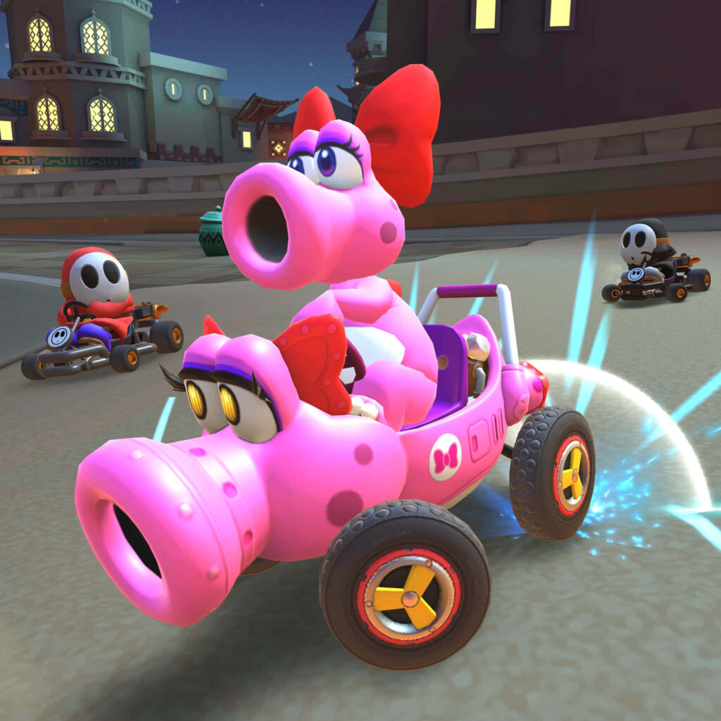 Birdo racing energetically in colorful go-kart with other racers on vibrant track background Wallpaper