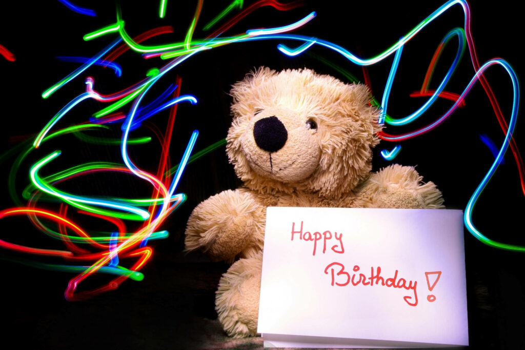 Neon Birthday Teddy: A Captivating Greeting Amidst the Darkness Wallpaper