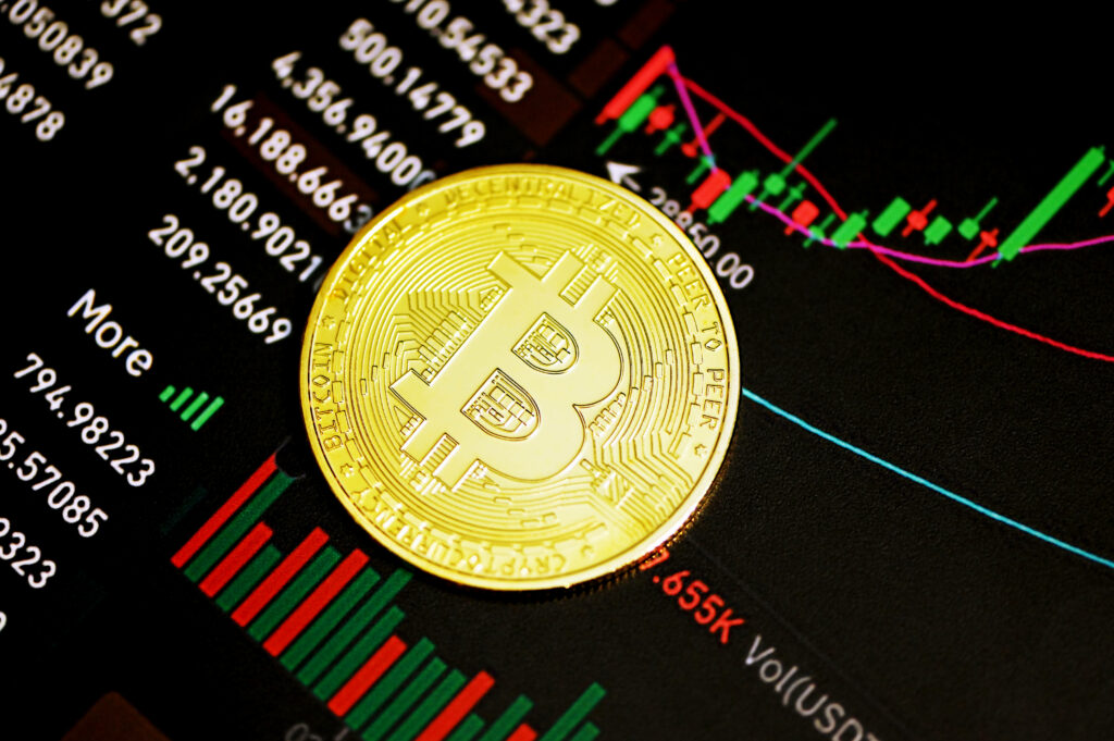 Golden Bitcoin coin on digital candlestick chart showing bitcoin market trend analysis wallpaper