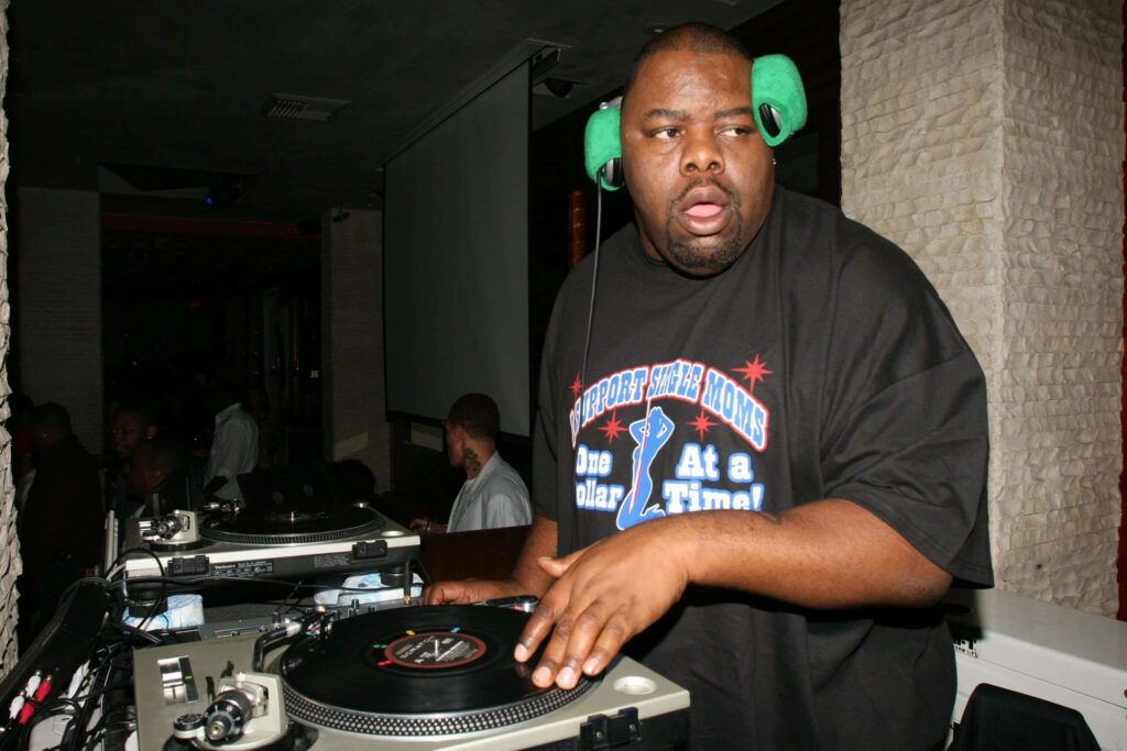 Biz Markie DJing live at vibrant club event with headphones and turntables wallpaper background