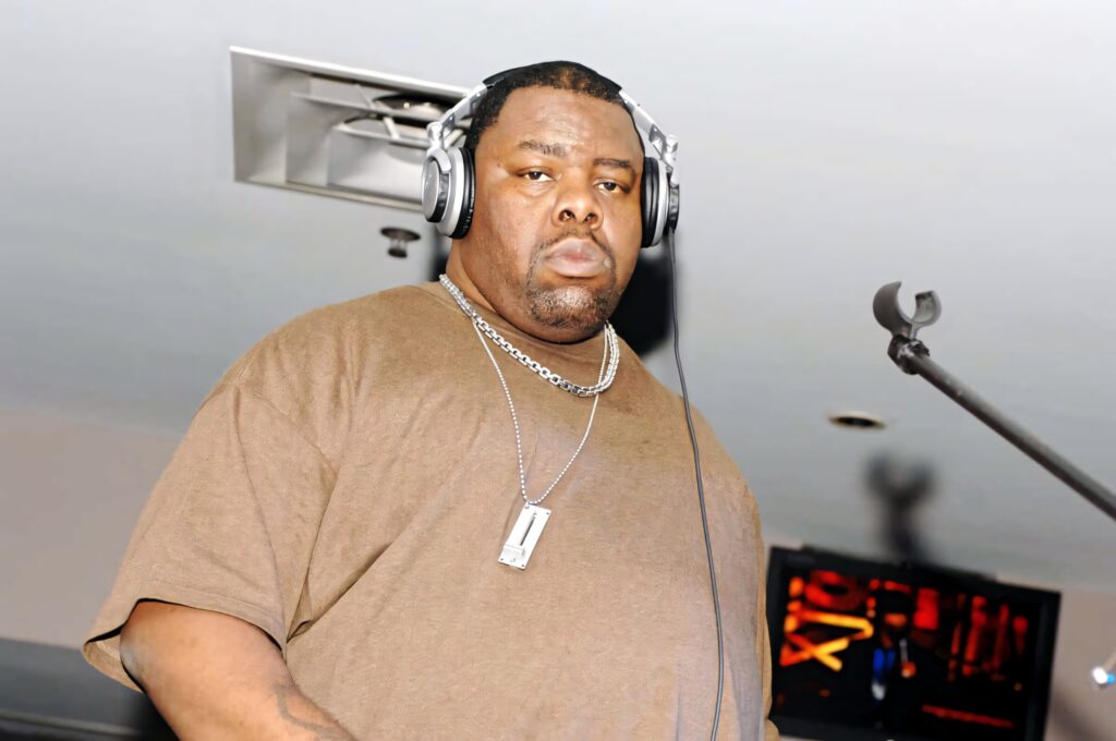 Biz Markie DJing live wearing headphones and brown t-shirt energetic style wallpaper background