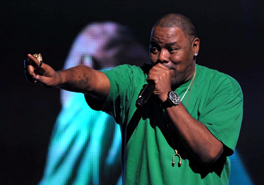 Biz Markie performing live on stage in green shirt with microphone dynamic lighting wallpaper