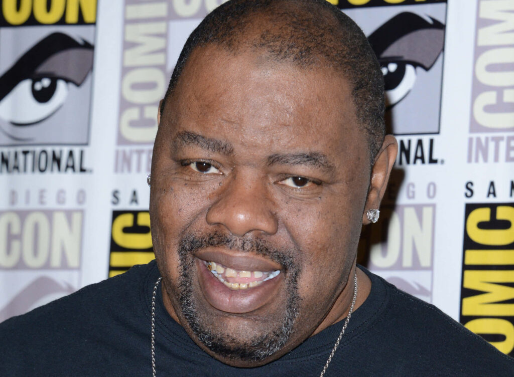 Biz Markie rapper at Comic Con event with iconic backdrop vibrant wallpaper background