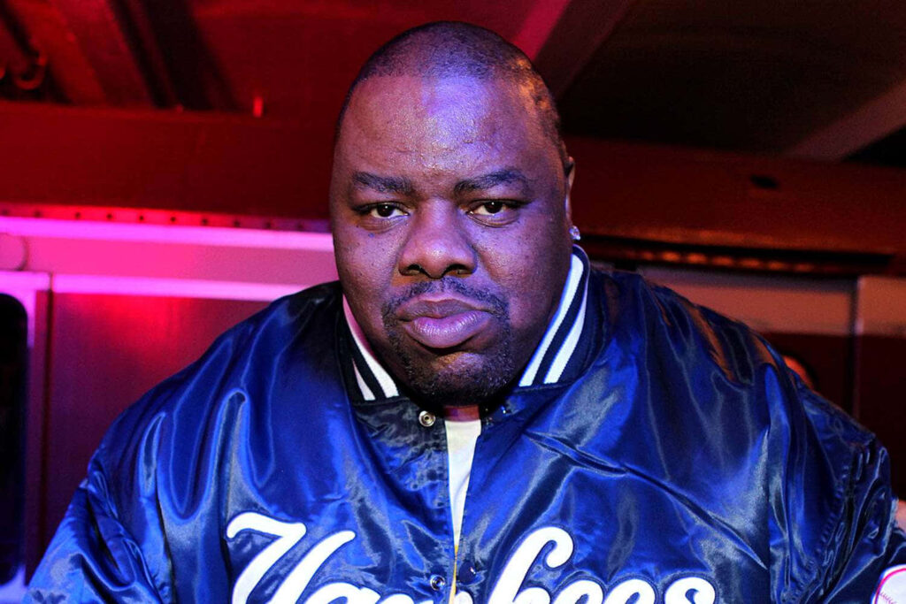 Biz Markie in blue Yankees jacket vibrant hip hop artist wallpaper background iconic style
