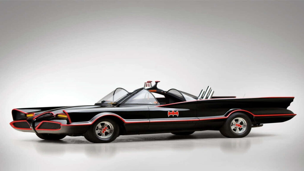 Batmobile in Action: Side View of Sleek Replica, Highlighting Red Design on Gray Background Wallpaper