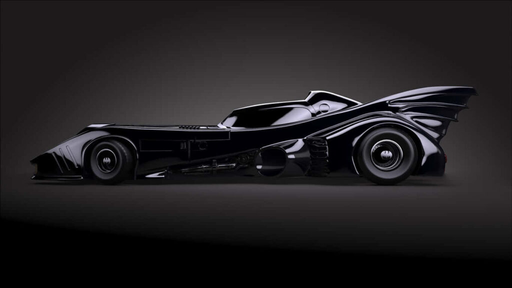 Sleek and Stylish: The Iconic Black Batmobile Glistens in the Shadows Wallpaper