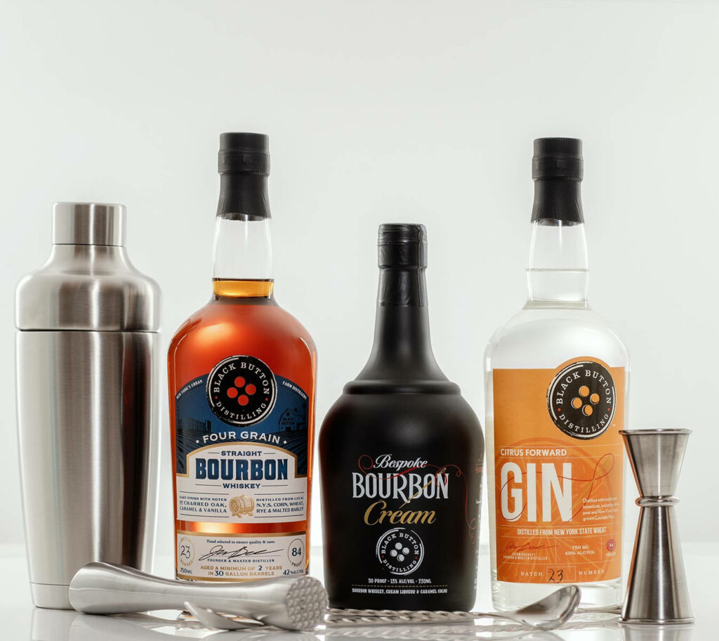 Black Button Distilling spirits lineup with Four Grain Bourbon Bespoke Cream Citrus Gin and bar tools Wallpaper