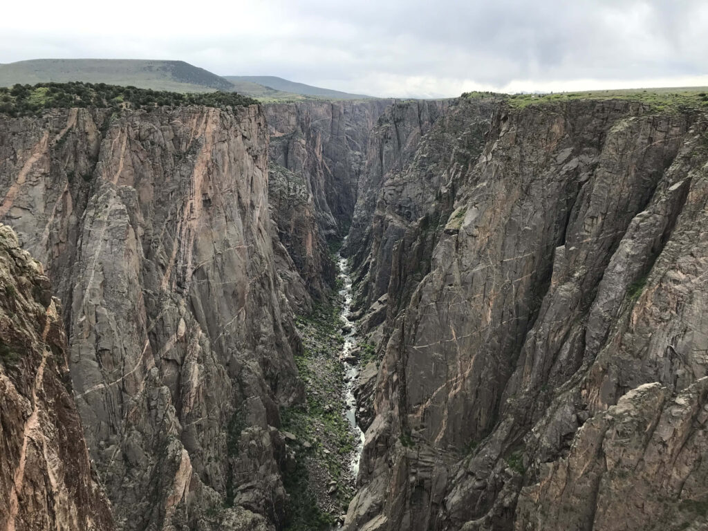 Dramatic cliffs and lush greenery in Black Canyon rugged gorge natural landscape wallpaper background