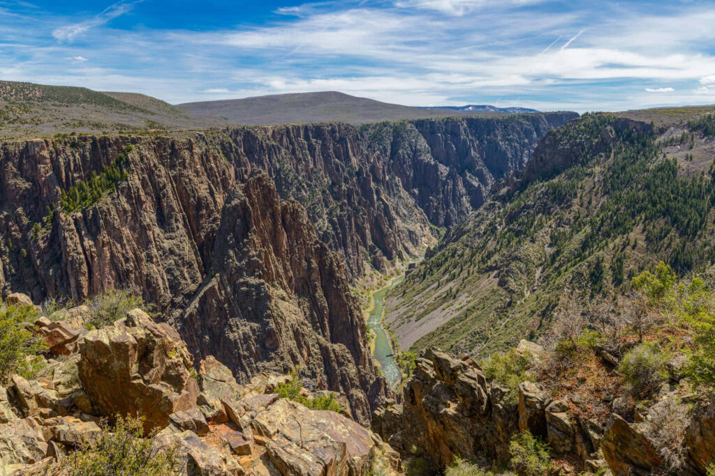 Black Canyon cliffs with winding river under vibrant blue sky natural rugged landscape wallpaper