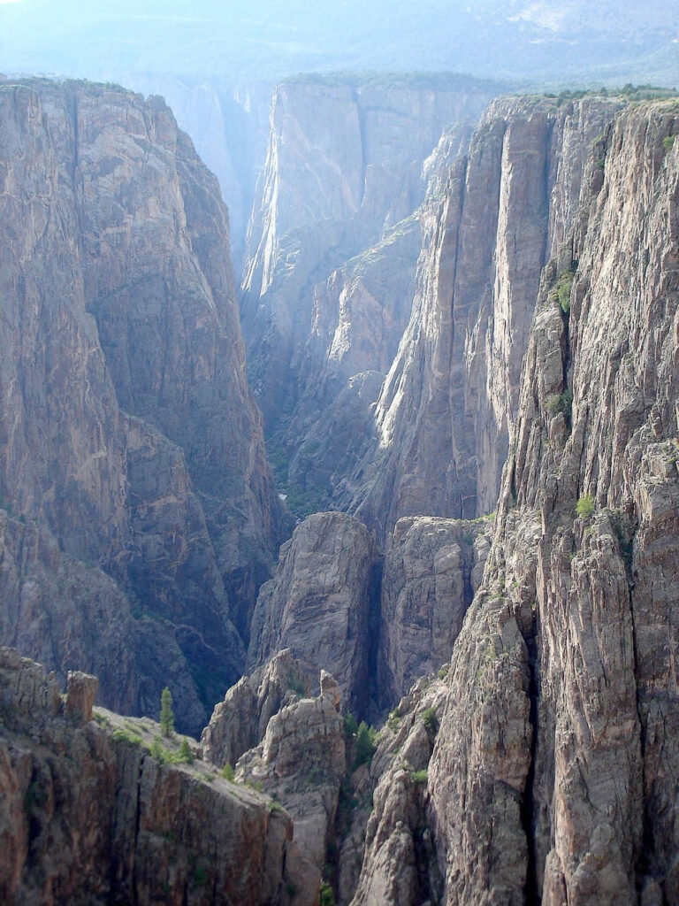 Black Canyon wallpaper with dramatic sheer cliffs rugged rock formations and soft natural light