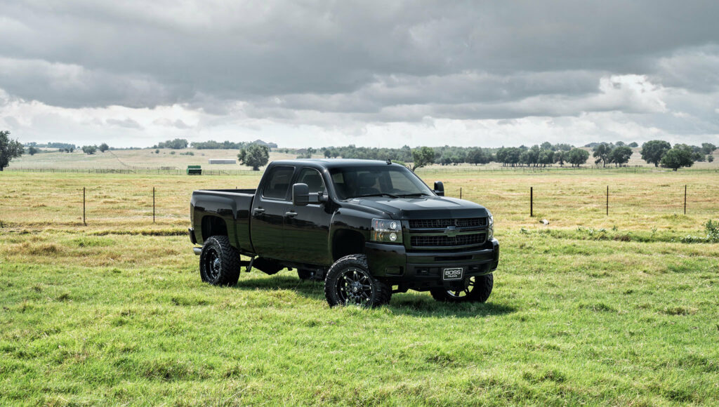 Black Chevrolet Avalanche in Vast Field: Rugged Truck Wallpaper