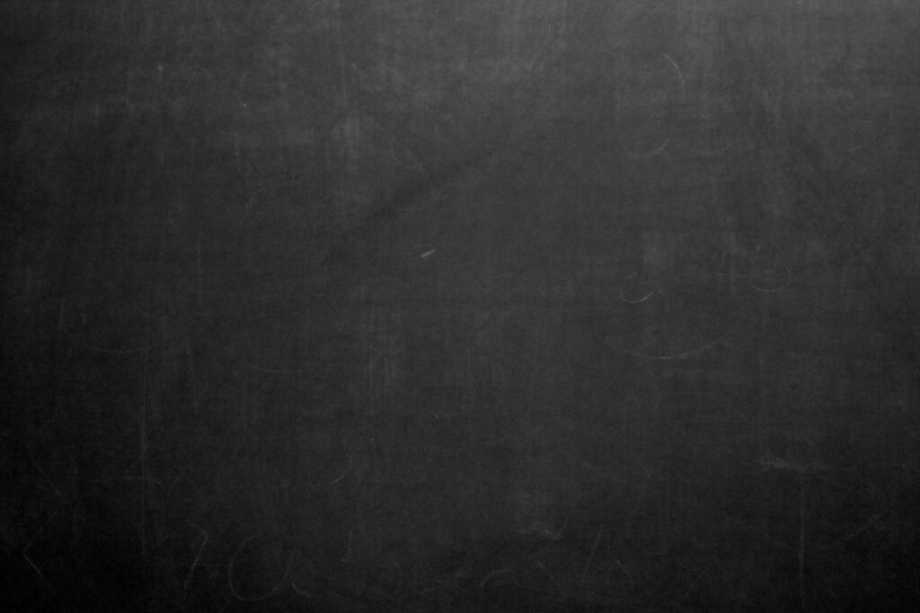 Black dusty chalkboard texture with subtle smudges and chalk marks vintage wallpaper background