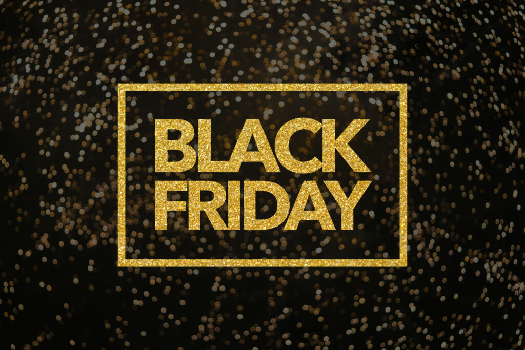 Black Friday gold glitter lettering on dark festive background with shimmering bokeh lights Wallpaper