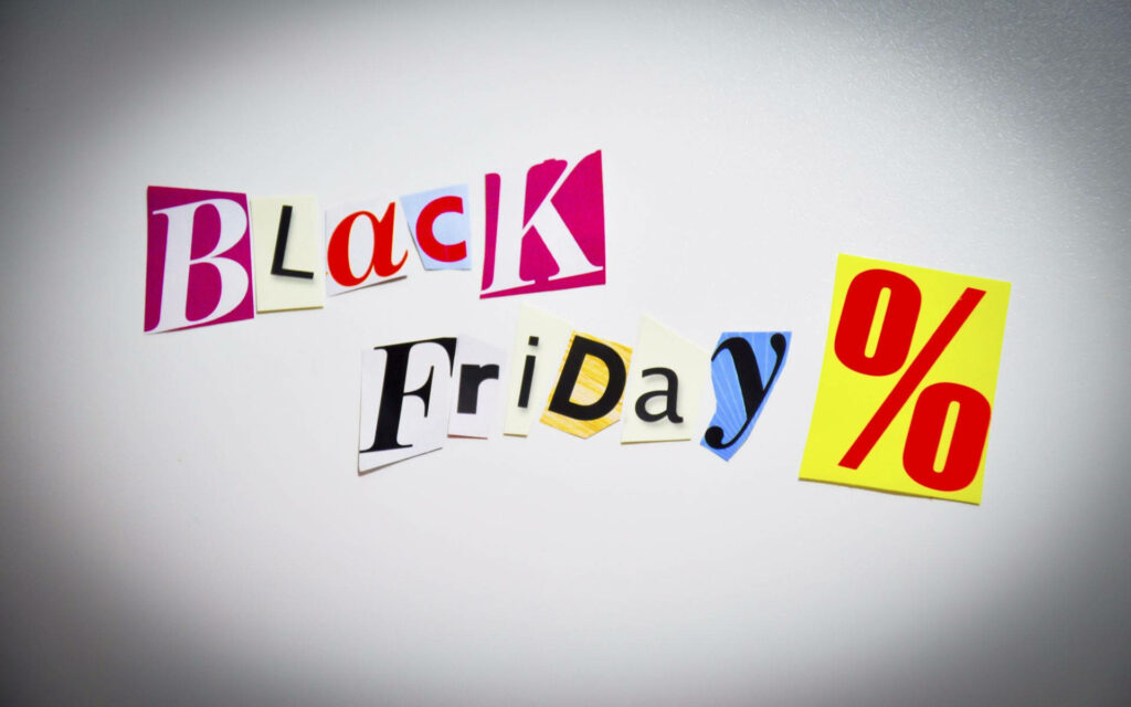 Black Friday text with colorful magazine cutout letters and percentage sign on white background Wallpaper