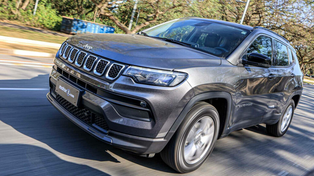 Black Jeep Compass angled shot driving on sunlit road showcasing bold modern design wallpaper