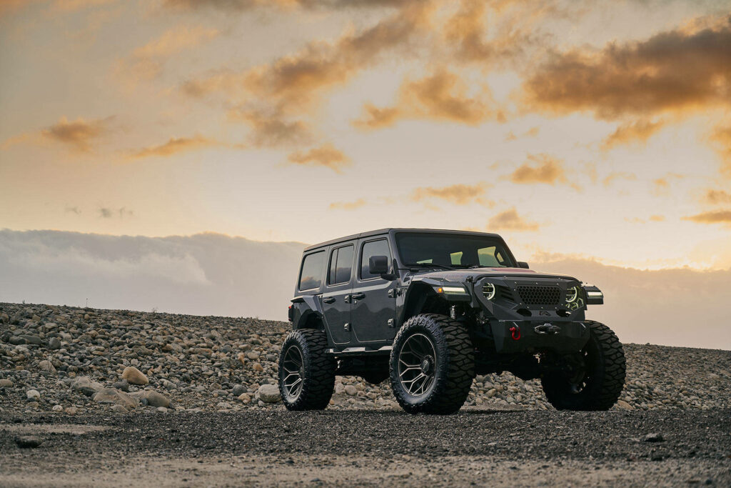 Conquering the Wild: The Badass Black Jeep Wrangler Roaming with Giant 4x4 Wheels Wallpaper