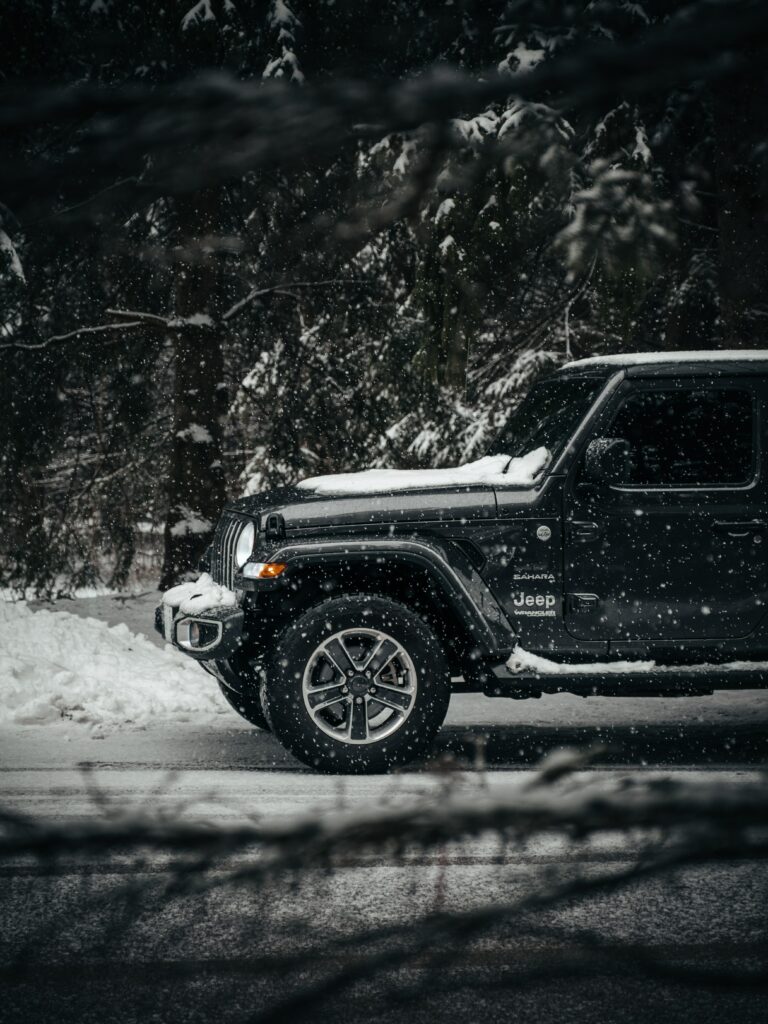 Black Jeep Wrangler in Snowy Forest: Rugged Design Meets Winter Beauty Wallpaper