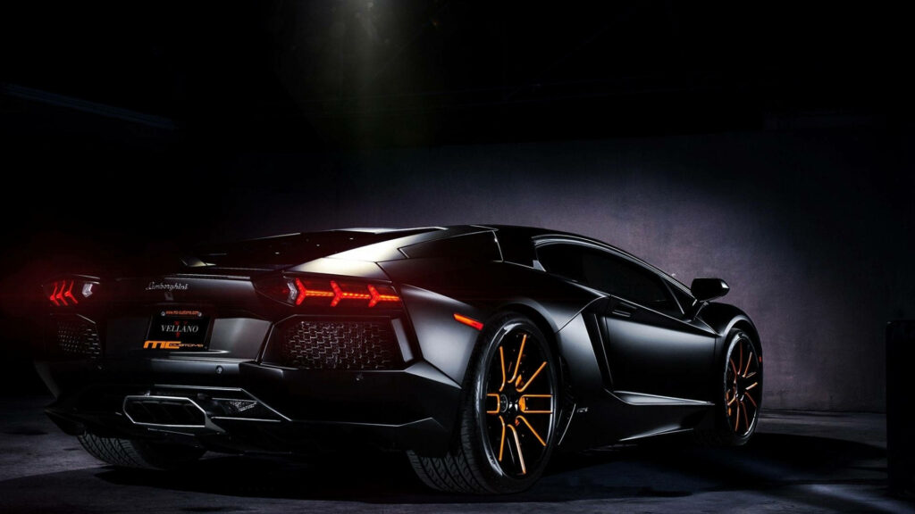 Black Lamborghini Aventador S rear view with sleek design and bold orange-accented wheels wallpaper