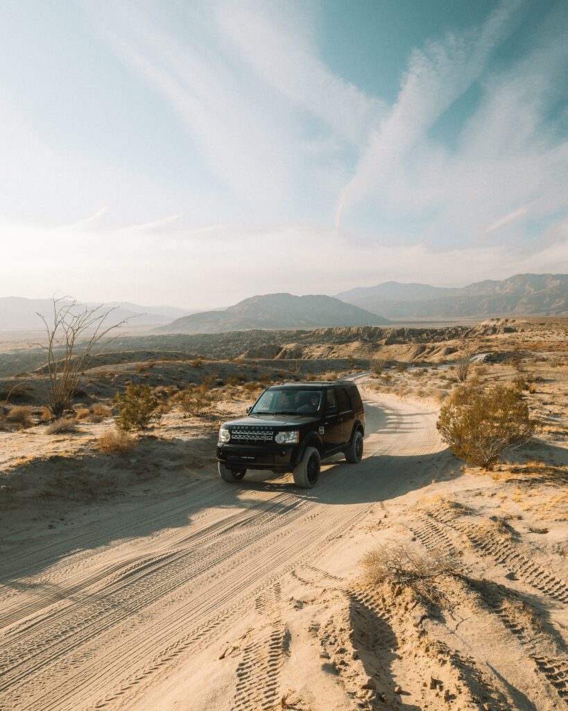 Black Land Rover SUV in Scenic Desert Landscape with Clear Sky Wallpaper