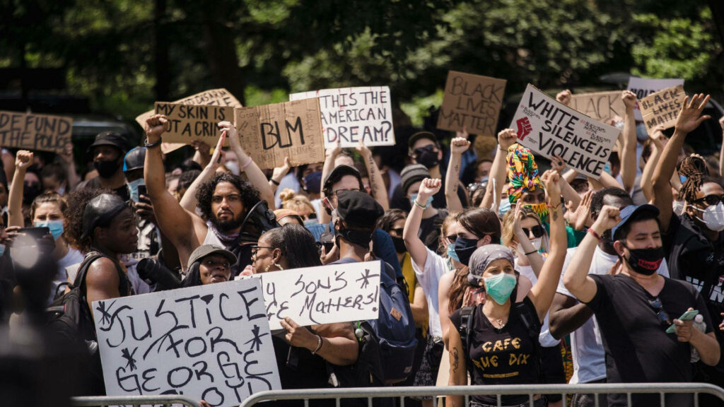 Protesters raising fists holding signs demanding justice for George Floyd Black Lives Matter rally Wallpaper