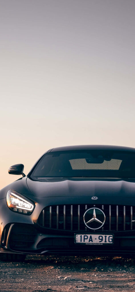 Front view of black Mercedes AMG with bold grille and emblem against serene sky background Wallpaper