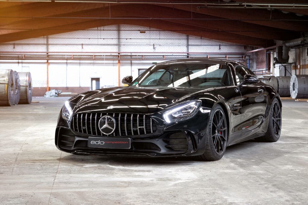 Black Mercedes AMG GT R in industrial warehouse showcasing bold aggressive design and power Wallpaper