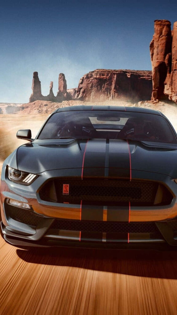Black Mustang muscle car racing through desert landscape powerful sleek iPhone wallpaper background