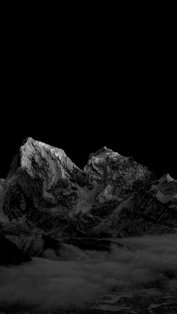 High-contrast monochrome OLED wallpaper with jagged snow-capped mountains above clouds background