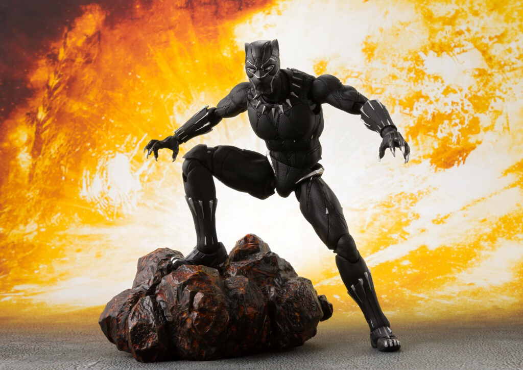 Black Panther action figure posed on rock with fiery background 4K Ultra HD wallpaper