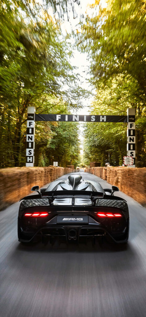 Rear view of Black Project One Mercedes AMG racing fast on tree-lined road high-performance car Wallpaper