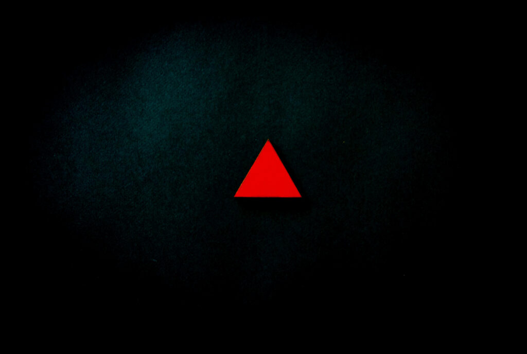 Dramatic Minimalism: A Striking 4k Black and Red Wallpaper, Showcasing a Subtle Crimson Triangle Against a Mysterious Depths