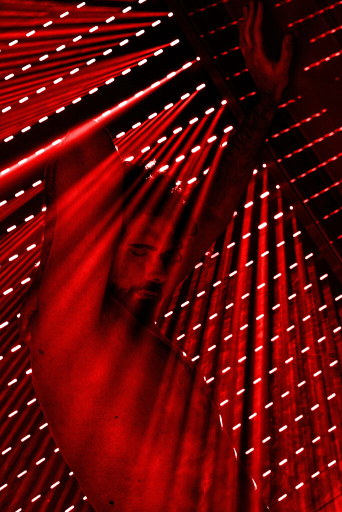 Grating Ambience: A Stylish Man Striking a Pose in Red Illumination - Captivating 4K Wallpaper