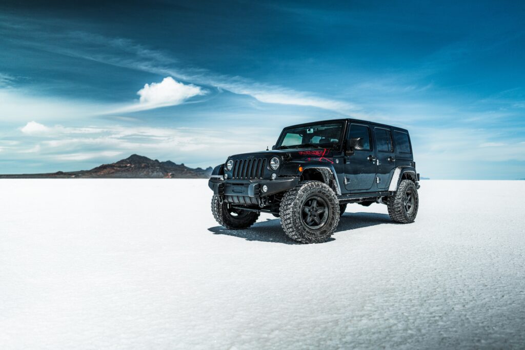 Rugged Black SUV in Stunning Desert Landscape with Clear Blue Sky Wallpaper