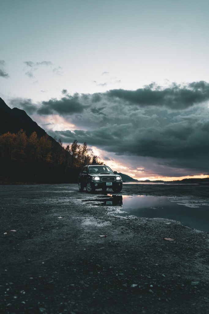 Black SUV on Rugged Terrain at Dusk - Nature Background Wallpaper