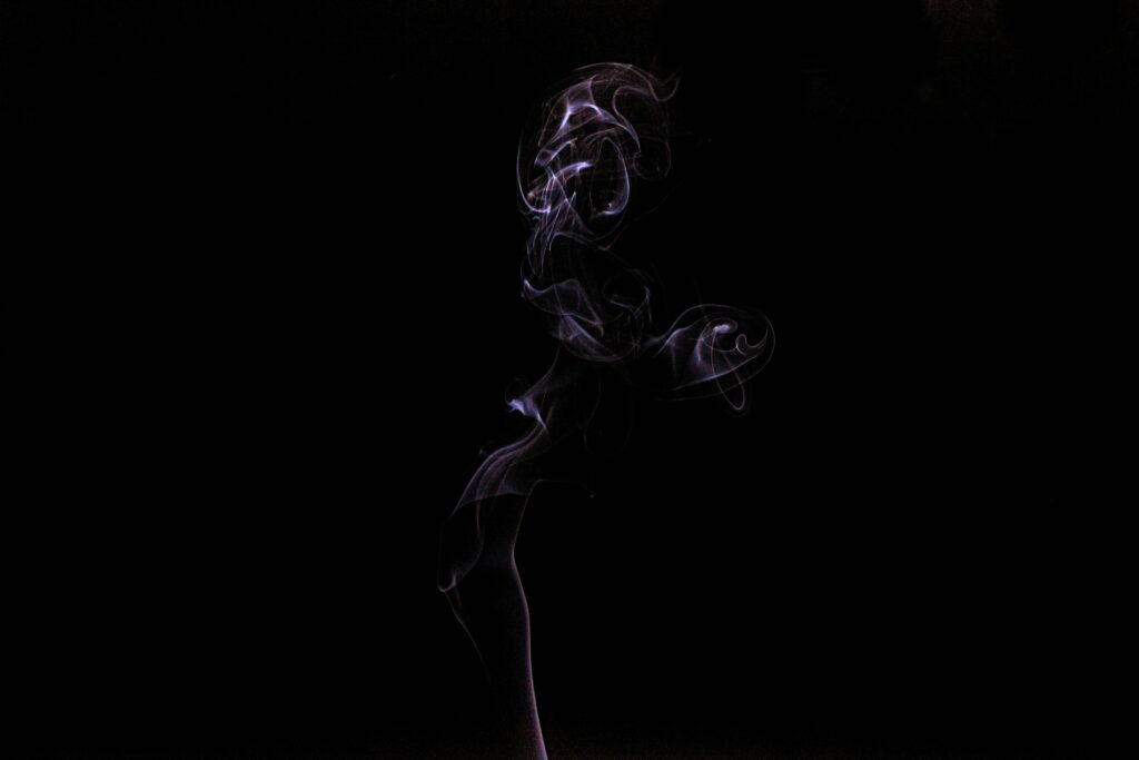 Delicate white smoke plume with blue purple highlights on black background 4K wallpaper