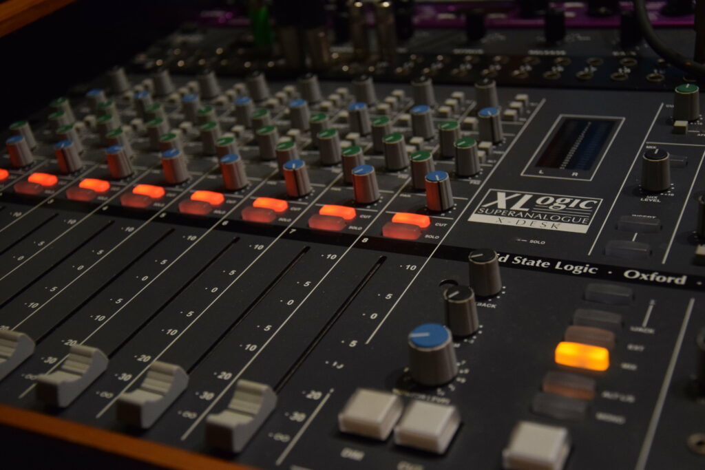 XL Logic Power: Capturing Studio Quality Sound with Black Stereo Amplifier and Console on Wallpaper Background