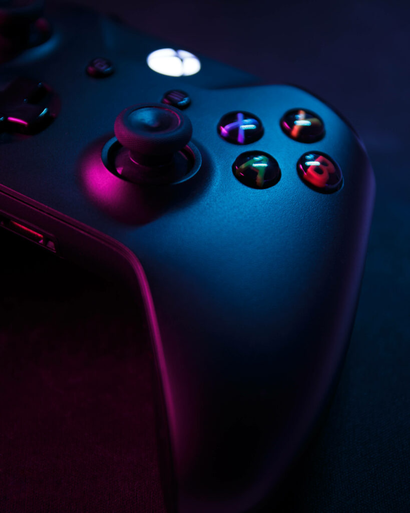 Close-Up of a Black Xbox Controller against a Backdrop of Ultimate Gaming Vibes Wallpaper