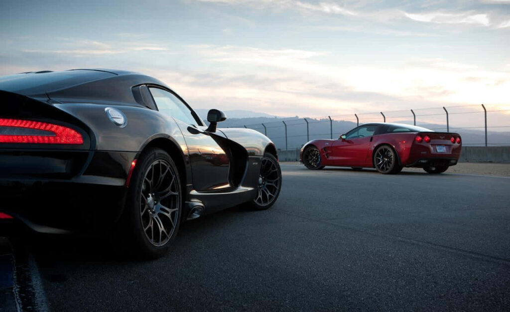 Black and red Dodge Vipers parked on racetrack at sunset showcasing bold high-performance design Wallpaper